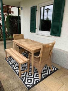 une table en bois, deux chaises et un banc dans l'établissement Chiemsee Schwanenloft, à Seeon-Seebruc