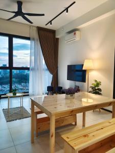 uma sala de estar com uma mesa de madeira e uma televisão em Georgetown Comfy Homestay em Jelutong