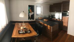 a kitchen with a wooden table and a counter top at Zentral, Ruhig, Sonnig, Modern in Lenzerheide