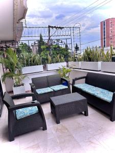 een patio met stoelen en tafels op een balkon bij The View Hostel & Lounge in Cali