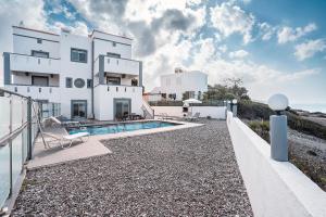 a white house with a swimming pool in front of it at Blue Pearl Apolakkia in Apolakkiá