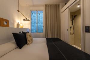a bedroom with a large white bed and a window at Hostal Boutique Es Menut in Tossa de Mar