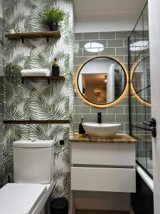a bathroom with a sink and a mirror at Spacious and modern flat in Archway in London