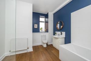 a bathroom with a toilet and a sink and a mirror at Ascot House Apartment in Hurstpierpoint
