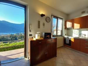 a kitchen with a large sliding glass door with a view at Holiday Home - Lake and Guzzi view in Mandello del Lario
