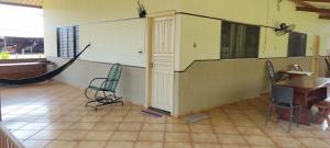 a room with two chairs and a table and a hammock at Casa aconchegante próximo ao Rio Dourados in Dourados