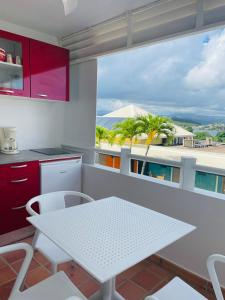 eine Küche mit einem weißen Tisch und weißen Stühlen in der Unterkunft TI BONHEUR DE TARTANE in La Trinité