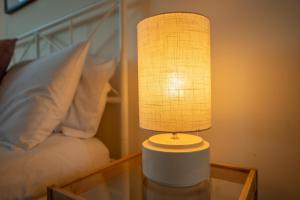 a lamp on a glass table next to a bed at Stylish Short Term Let - Bucks in Bourne End