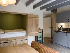ein Wohnzimmer mit einem Bett und eine Küche in der Unterkunft Groepsaccommodatie / Familiehuis Bolle Buik, Borrel & Bed Appelscha in Appelscha