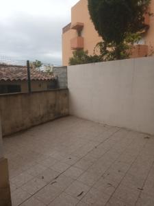 une terrasse avec un mur blanc et un arbre dans l'établissement Charmant et cosy 4 pcs, à Nice