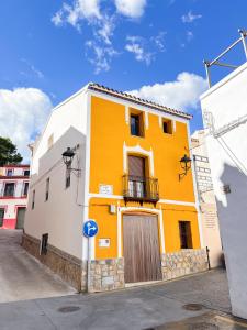 un edificio amarillo con balcón en una calle en Casa Rural La Travesía, en Bolulla