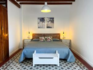 a bedroom with a bed with a blue bedspread at Casa Rural La Travesía in Bolulla