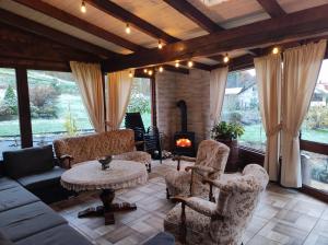 a living room with a couch and chairs and a fireplace at Dom Kowala in Jankowce