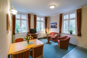 una sala de estar con sillas y una mesa y una habitación en Gästehaus am Kurpark, en Bad Schandau
