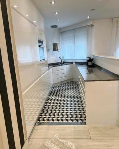 uma cozinha com piso em azulejo preto e branco em Apartamento Platas Centro em Ribadesella
