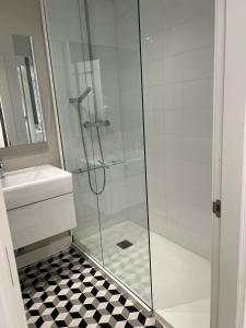 um chuveiro com uma porta de vidro ao lado de um lavatório em Apartamento Platas Centro em Ribadesella