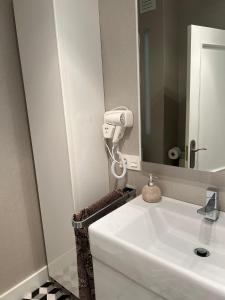 a bathroom with a white sink and a mirror at Apartamento Platas Centro in Ribadesella