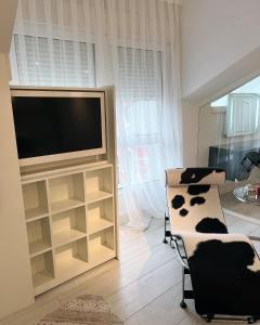 uma sala de estar com uma televisão de ecrã plano e uma cadeira em Apartamento Platas Centro em Ribadesella