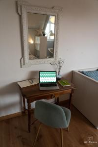 - un bureau avec un ordinateur portable, une chaise et un miroir dans l'établissement Les Beaux Jours, Tours, à Tours