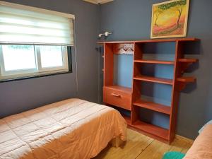 1 dormitorio con cama y estante para libros en Aires de Asturias, en Puerto Montt