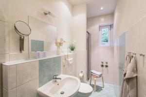 a bathroom with a sink and a toilet and a mirror at Gästehaus am Kurpark in Bad Schandau +12 photos