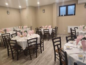 a room with tables and chairs with pink flowers on them at Hotel Tranzit in Odorheiu Secuiesc