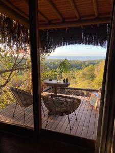 莫雷雷的住宿－Nature Moreré - Bangalôs com vista para o Mar，甲板上的窗户享有风景,配有桌椅