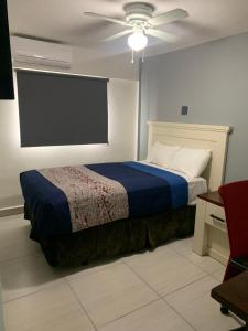 - une chambre avec un lit et un ventilateur de plafond dans l'établissement La Purisima Hotel, à La Paz