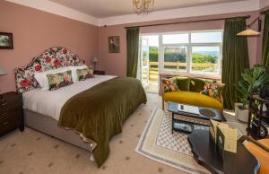 a bedroom with a bed and a chair and a window at Eype's Mouth Country Hotel in Bridport