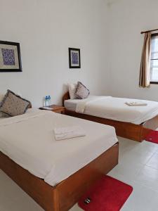 - 2 lits dans une chambre avec un tapis rouge dans l'établissement Sanhak Guesthouse 1, à Ban Nahin-Nai (2)