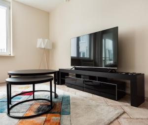 a living room with a table and a tv at Praga Sulejkowska Comfort Apartment in Warsaw