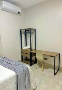 a bedroom with a desk and a chair next to a bed at Roma Flats in Campo Novo do Parecis