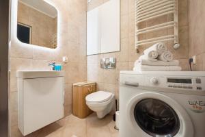 y baño con lavadora y aseo. en Praga Sulejkowska Comfort Apartment en Varsovia