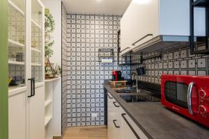 a kitchen with white cabinets and a red microwave at Villaggio Ippico - bambnb in Stupinigi