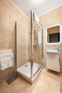 y baño con ducha y lavamanos. en Praga Sulejkowska Comfort Apartment en Varsovia