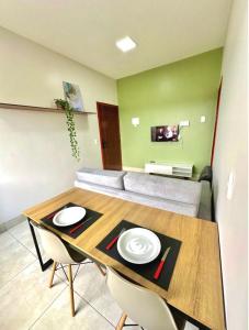 a dining room with a table and a couch at Roma Flats in Campo Novo do Parecis