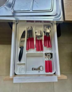 a plastic drawer with utensils in a refrigerator at Roma Flats in Campo Novo do Parecis
