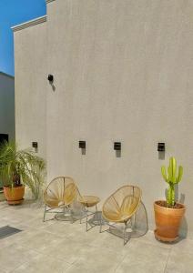 three chairs and a table in front of a building at Roma Flats in Campo Novo do Parecis