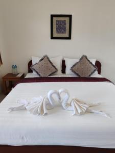 Sanhak Guesthouse 1 في Ban Nahin-Nai: غرفة نوم بسريرين مع شراشف بيضاء