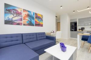 a living room with a blue couch and a table at Dark Blue and Grey Apartment with Pastel Bedroom in Warsaw by Renters in Warsaw