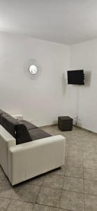 un salon avec un canapé blanc et une télévision dans l'établissement Appartamento Le Vele2, à Porto San Paolo