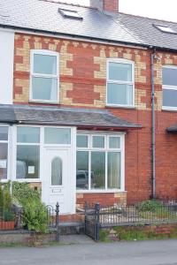 a red brick house with a white door and windows at Cadair View Family Holiday Home in Tywyn