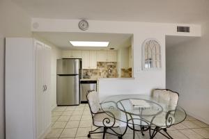 a kitchen with a glass table and chairs at Oceanfront Ormond Beach Condo Community Perks! in Ormond Beach
