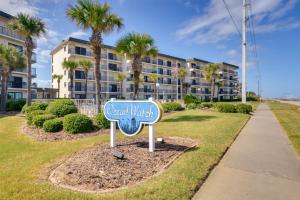 a sign in front of a building with palm trees at Oceanfront Ormond Beach Condo Community Perks! in Ormond Beach