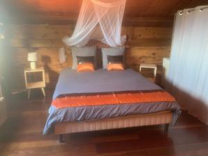 um quarto com uma cama num chalé de madeira em Bali Serenity Home em Saint-Leu