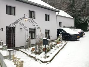 a white building with an arch in the snow at Um Burebierg apartment 35m2 in Buschrodt