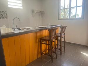 a kitchen with a sink and two bar stools at Mountain Breeze Home Rentals in Portsmouth