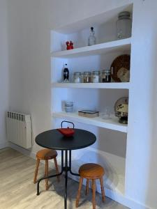 a table and two stools in a kitchen with shelves at Casa Alba 2023 in Lillo