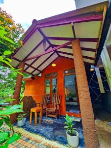 a porch of a house with two chairs and a table at Nice View Cottage in Udawalawe