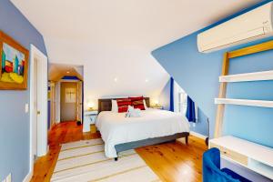- une chambre avec un lit et un mur bleu dans l'établissement Picabu Beach, à Provincetown